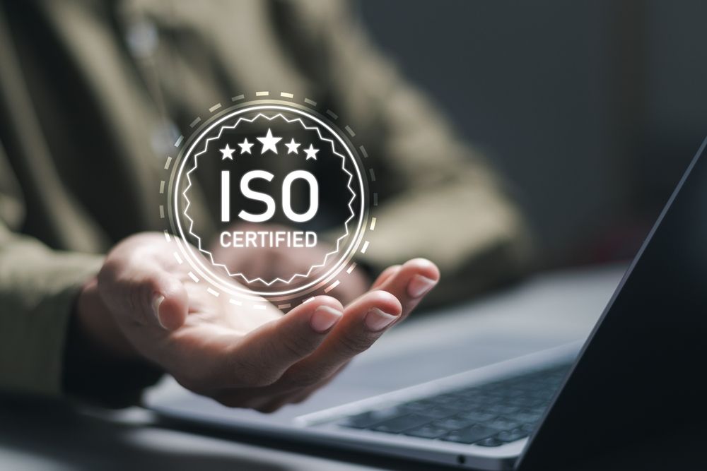 ISO certification concept image showing an ISO certified badge above a business professional’s hand
